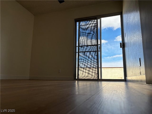 empty room featuring baseboards and wood finished floors