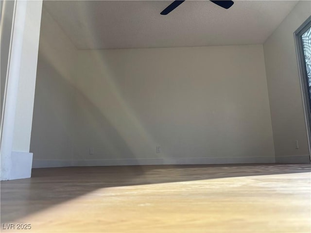 bonus room with wood finished floors, baseboards, and ceiling fan