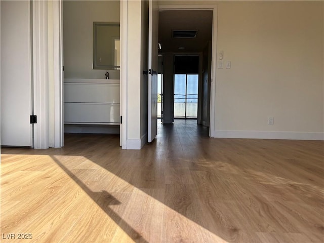 interior space featuring visible vents, baseboards, and wood finished floors