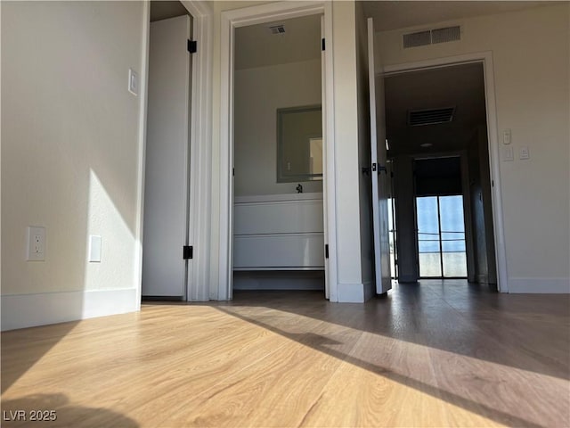 interior space featuring wood finished floors, visible vents, and baseboards