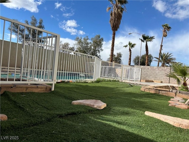 view of yard with a swimming pool and a fenced backyard