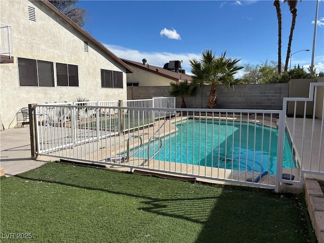 view of swimming pool featuring a patio, a yard, a fenced backyard, and a fenced in pool