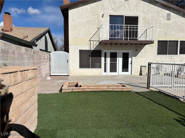 back of house with a patio, a balcony, a gate, fence, and stucco siding