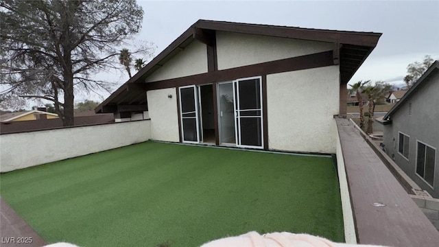 rear view of property featuring stucco siding