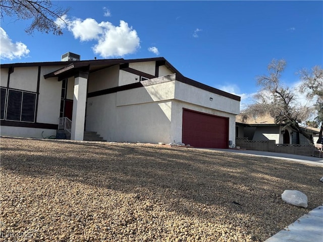 view of property exterior with an attached garage, driveway, and stucco siding