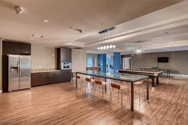 rec room with recessed lighting, baseboards, light wood finished floors, and visible vents