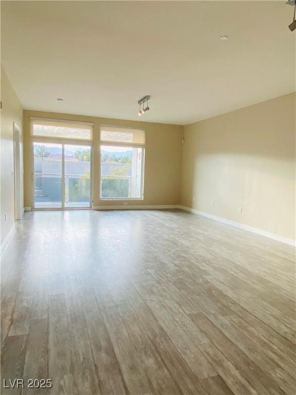 empty room with baseboards and wood finished floors