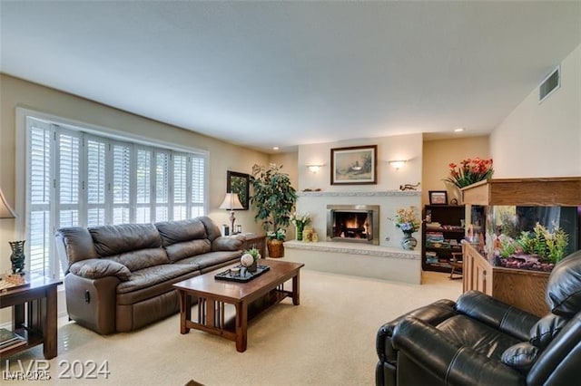 living area with recessed lighting, visible vents, light colored carpet, and a lit fireplace