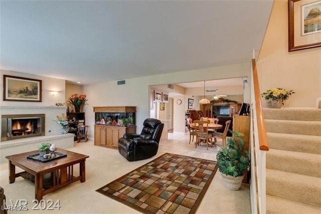 living room with stairs, light carpet, visible vents, and a premium fireplace