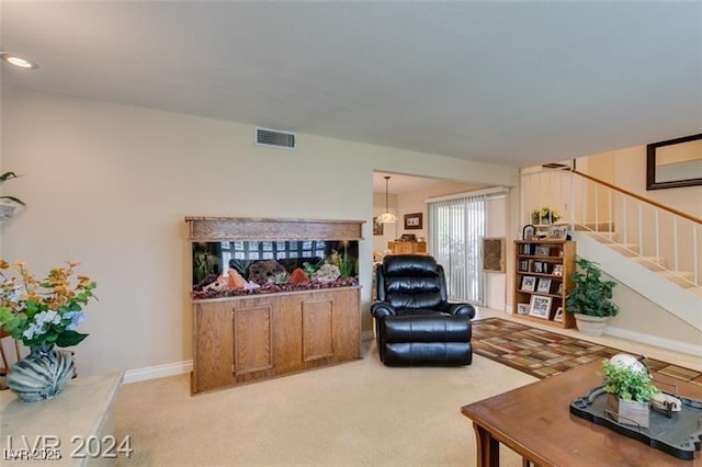 living area featuring stairs, light colored carpet, visible vents, and baseboards