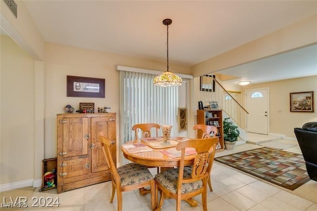 dining area with visible vents, an inviting chandelier, light tile patterned flooring, a healthy amount of sunlight, and stairs