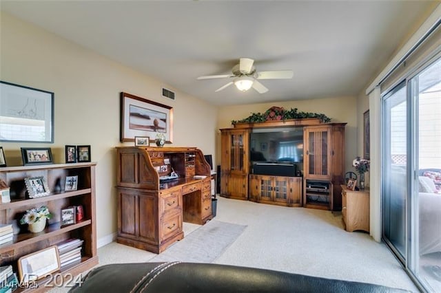 office space with light carpet, visible vents, and ceiling fan