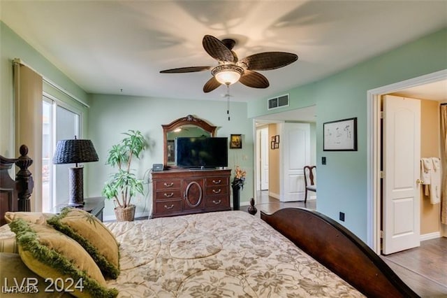 bedroom featuring a ceiling fan, wood finished floors, visible vents, and baseboards