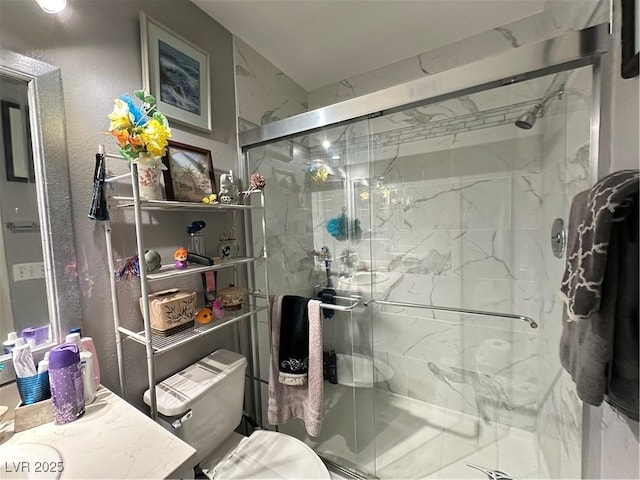 bathroom featuring vanity, a shower stall, and toilet