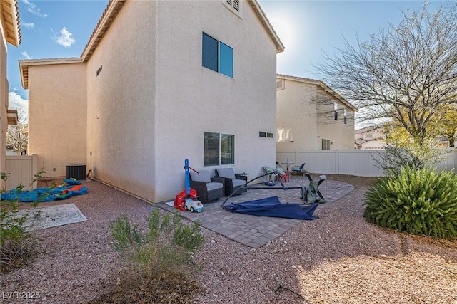 back of property with stucco siding, fence, and a patio area