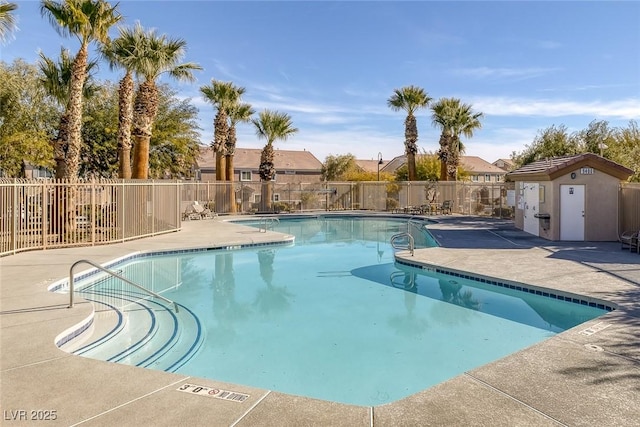 community pool with a patio and fence