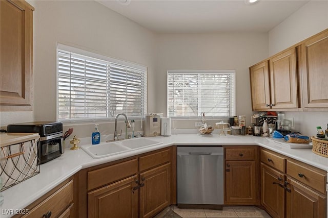 kitchen featuring dishwasher, light countertops, light tile patterned floors, and a sink