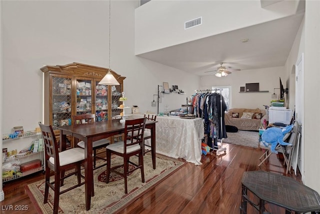 dining space featuring ceiling fan, visible vents, and wood finished floors