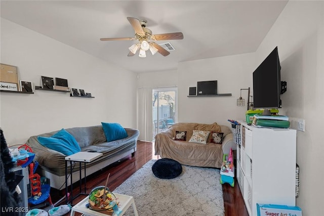 living room with visible vents, wood finished floors, and a ceiling fan