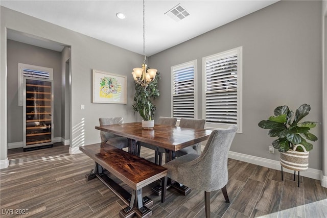 dining space featuring a notable chandelier, visible vents, baseboards, and wood finished floors