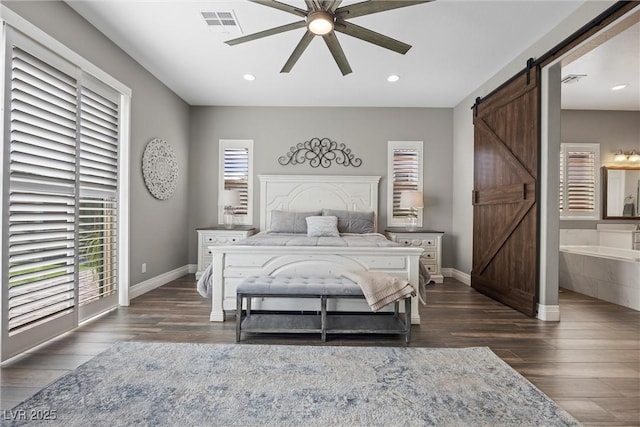 bedroom featuring dark wood finished floors, recessed lighting, baseboards, and a barn door