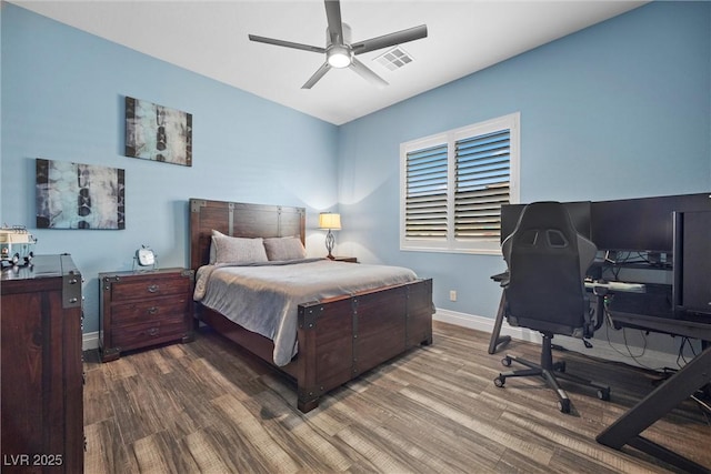 bedroom with ceiling fan, visible vents, baseboards, and wood finished floors