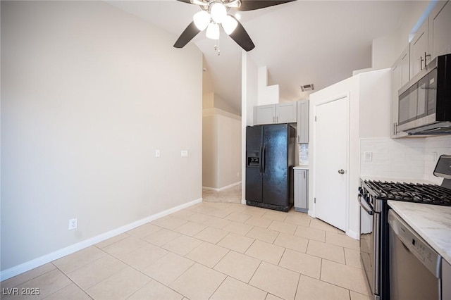 kitchen with backsplash, stainless steel appliances, baseboards, ceiling fan, and vaulted ceiling