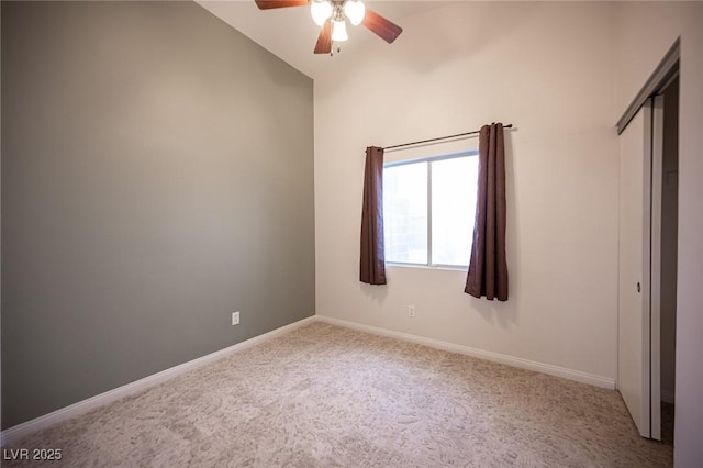 unfurnished bedroom featuring baseboards, ceiling fan, vaulted ceiling, a closet, and carpet flooring