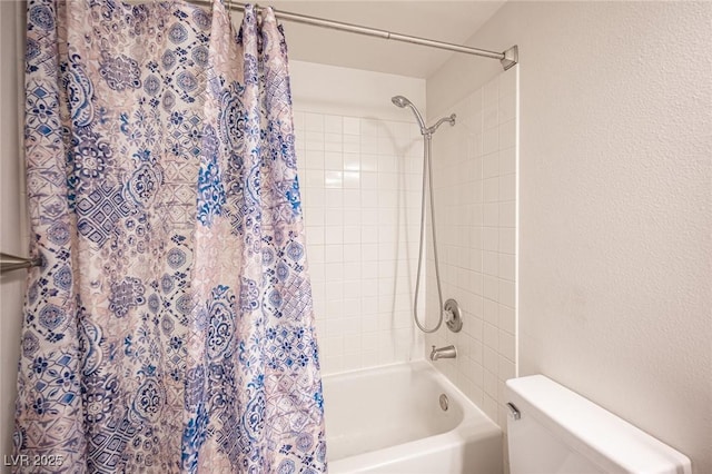 bathroom featuring shower / tub combo, toilet, and a textured wall