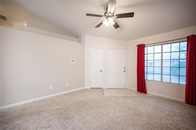 spare room featuring lofted ceiling, light colored carpet, baseboards, and ceiling fan