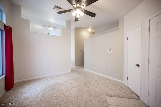 unfurnished room with baseboards, light colored carpet, visible vents, and ceiling fan