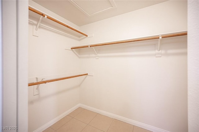 walk in closet with light tile patterned floors