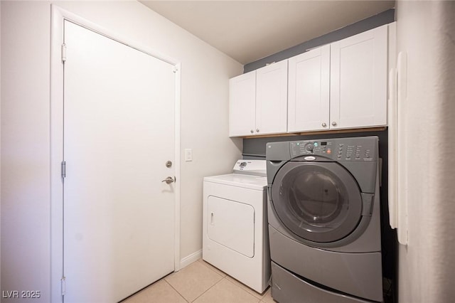 laundry area featuring light tile patterned floors, cabinet space, baseboards, and separate washer and dryer