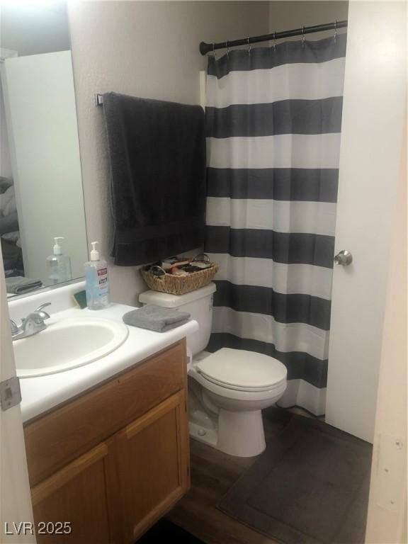 full bathroom featuring a shower with shower curtain, toilet, and vanity