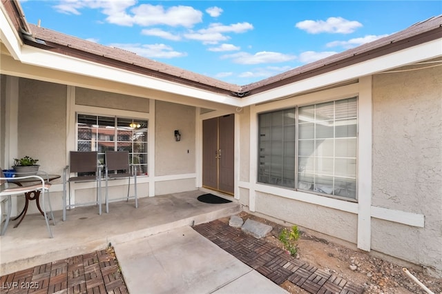 entrance to property featuring stucco siding