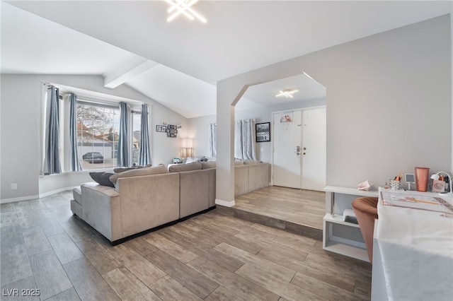 living room featuring lofted ceiling with beams, baseboards, arched walkways, and wood tiled floor