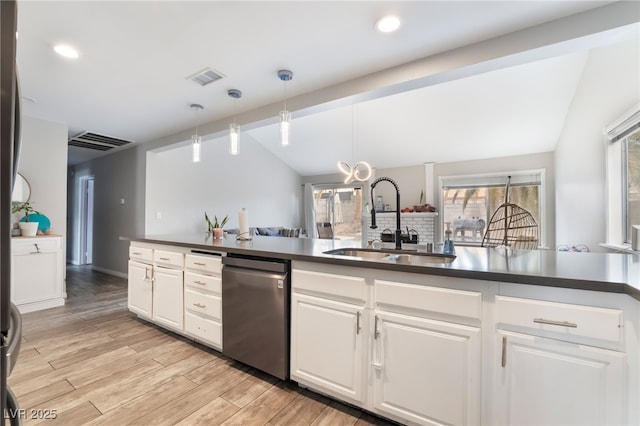 kitchen featuring visible vents, lofted ceiling, a sink, dark countertops, and light wood-type flooring