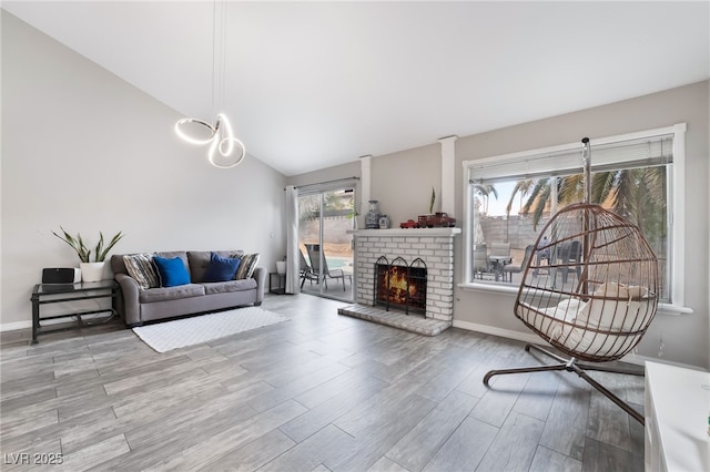 living room with a fireplace, lofted ceiling, wood finished floors, and baseboards