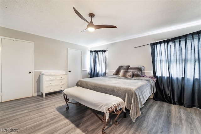 bedroom with a ceiling fan, lofted ceiling, and wood finished floors