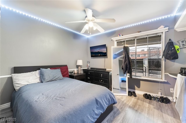 bedroom with wood finished floors, baseboards, and ceiling fan