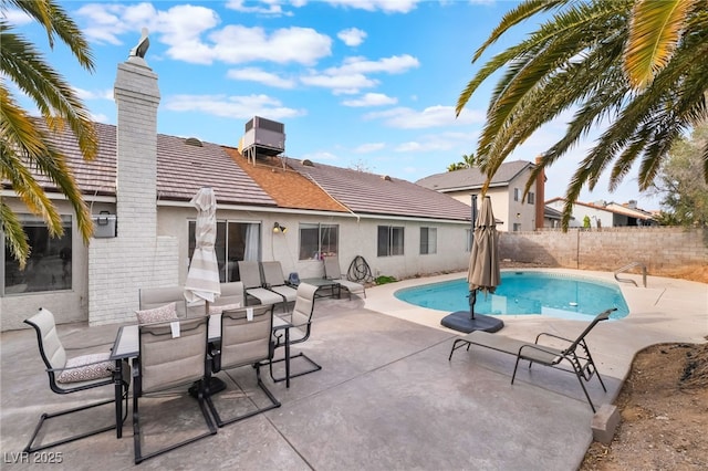 view of pool with outdoor dining space, fence, a fenced in pool, central air condition unit, and a patio area