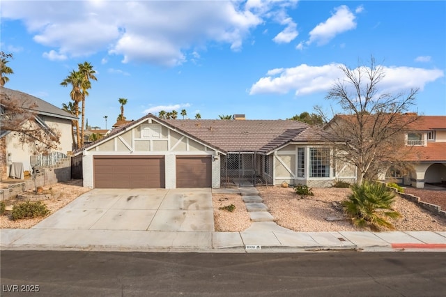 view of front of home featuring a tile roof, an attached garage, a chimney, and driveway