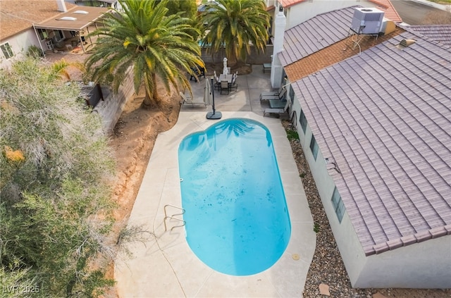 view of pool featuring a patio area, a fenced in pool, cooling unit, and a fenced backyard