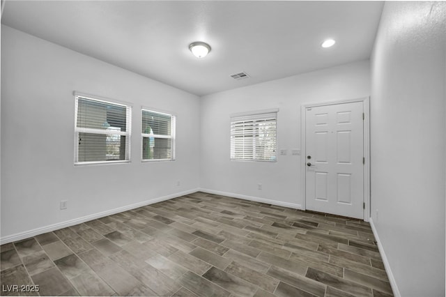 empty room featuring recessed lighting, visible vents, baseboards, and wood finished floors