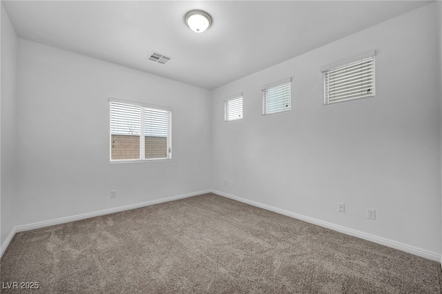 empty room featuring visible vents, baseboards, and carpet floors