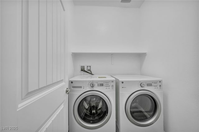 clothes washing area with washer and dryer and laundry area