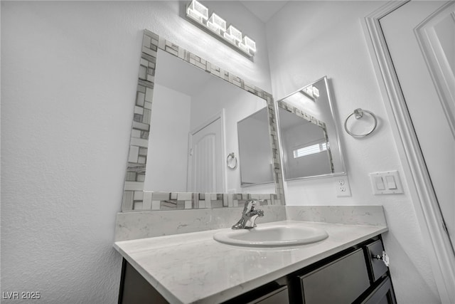 bathroom featuring vanity and a textured wall