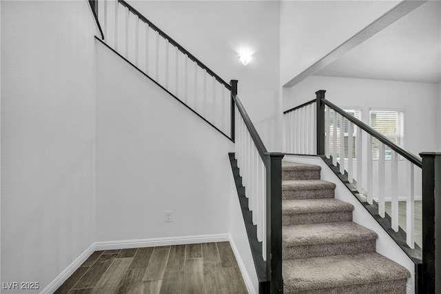 staircase with wood finished floors and baseboards