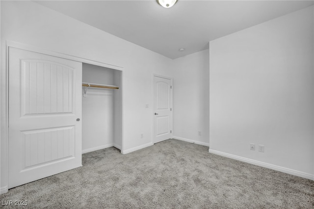 unfurnished bedroom with a closet, carpet flooring, and baseboards