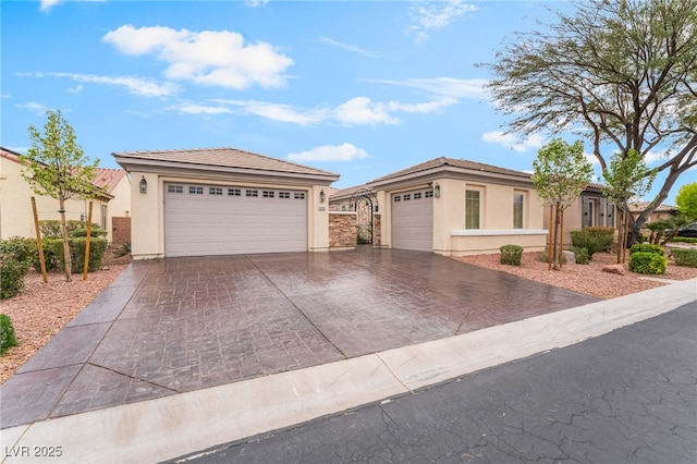 view of front of home with stucco siding, driveway, and a garage